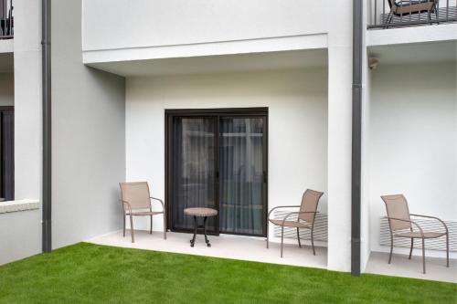 a patio with chairs and a table and grass at Courtyard by Marriott New Haven Wallingford in Wallingford