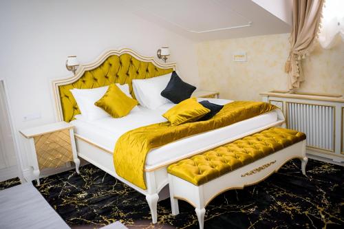 - une chambre dotée d'un grand lit avec des couvertures et des oreillers jaunes dans l'établissement Cochet House Sibiu, à Sibiu