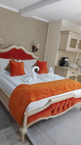 a bedroom with a large bed with orange and white pillows at Cochet House Sibiu in Sibiu