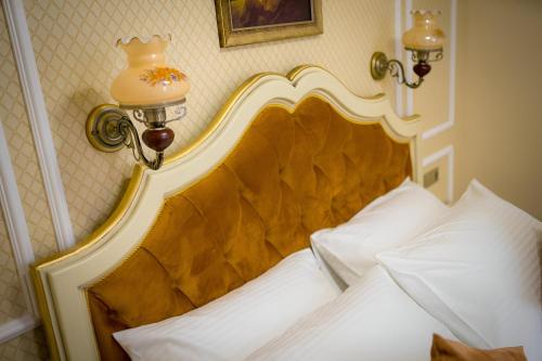 un lit avec une tête de lit dorée dans une chambre dans l'établissement Cochet House Sibiu, à Sibiu