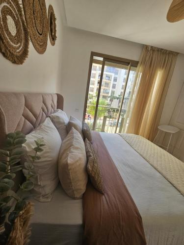 1 dormitorio con cama con almohadas y ventana en Airport Break en Nouaceur