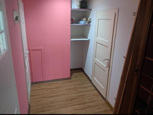Habitación con puerta rosa y suelo de madera. en Anil Best Place, en Nepālganj
