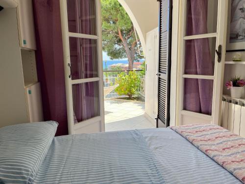 1 dormitorio con 1 cama y puerta abierta en Casa La Perla - Alloggio con terrazza panoramica, piscina e free parking en Ceriale