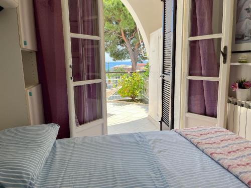 a bedroom with a bed and an open door at Casa La Perla - Alloggio con terrazza panoramica, piscina e free parking in Ceriale