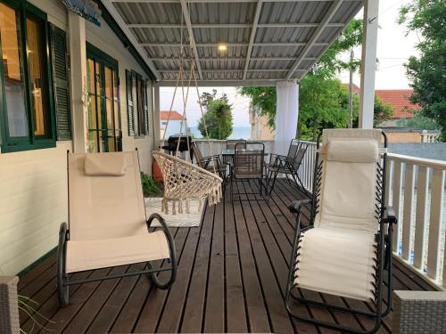 a porch with two chairs and a table on it at Privlaka Mobilhouses in Privlaka