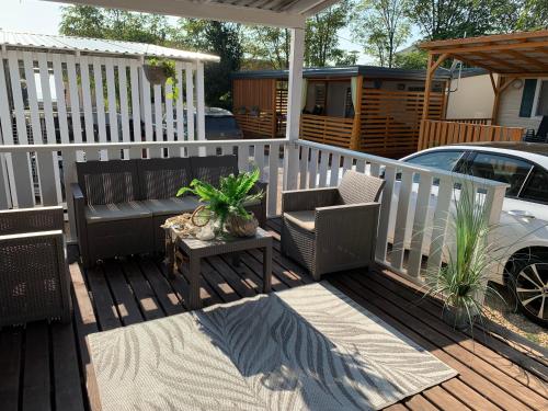 a wooden deck with a bench and a table at Privlaka Mobilhouses in Privlaka