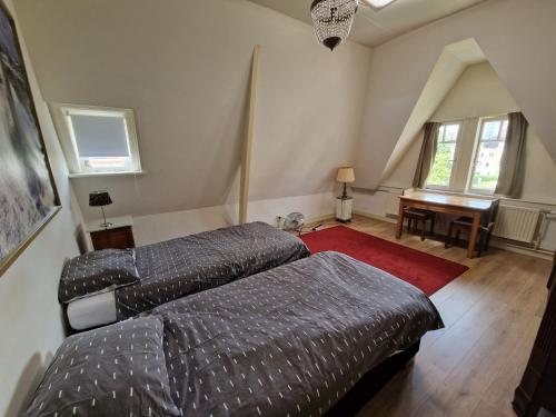 1 dormitorio con 2 camas, escritorio y piano en J&J, en Nijmegen