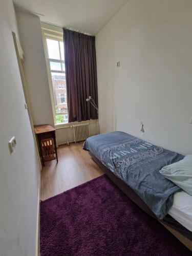 a bedroom with a bed and a purple rug at J&J in Nijmegen