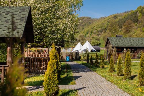 a path in a garden with tents and trees at Рибничанка in Skhidnitsa