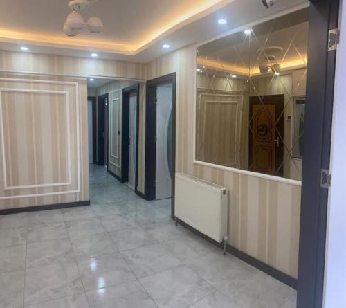 um corredor com muitas portas de vidro e um piso de azulejo em Şehir Merkezinde Otel Konforunda Family House em Sivas