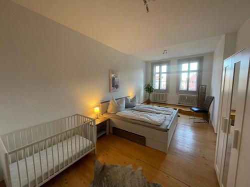 ein Schlafzimmer mit einem Bett und einem Kinderbett in der Unterkunft Brix Apartment in Naumburg