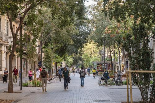 HoHomes - Luxury Palacete في برشلونة: مجموعة من الناس يمشون في شارع به اشجار