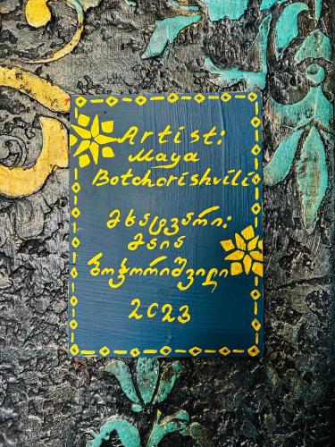 a sign on the side of a wall with graffiti at Hotel Zerta Old Tbilisi in Tbilisi City