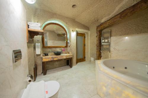 a large bathroom with a tub and a sink at Roma Cave Suite in Goreme