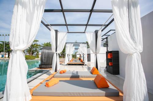a villa with a swimming pool with white curtains at Wonderland Suites and Resort in Sihanoukville