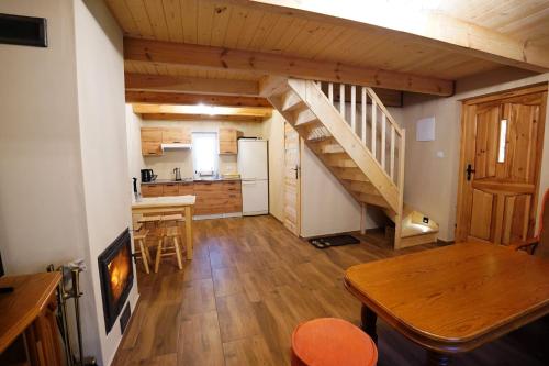ein Wohnzimmer mit einer Treppe und eine Küche in der Unterkunft Domek Pietryna in Chańcza