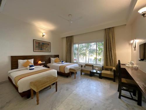 um quarto de hotel com duas camas e uma janela em A S Hotels em Khajuraho