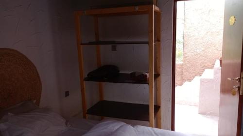Habitación con estantería junto a la cama en Riad Nizwa en Nizwa