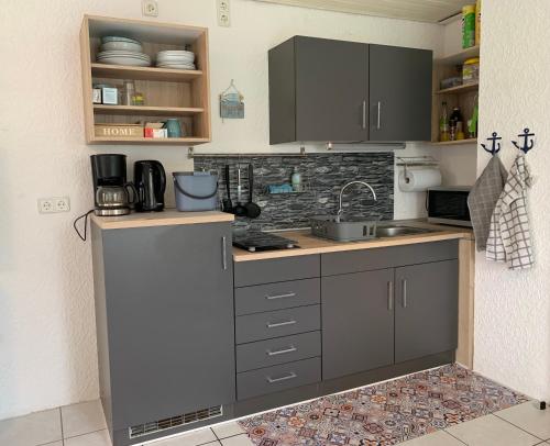 eine Küche mit grauen Schränken und einer Arbeitsplatte in der Unterkunft Ferienunterkunft Heidi in Blieskastel