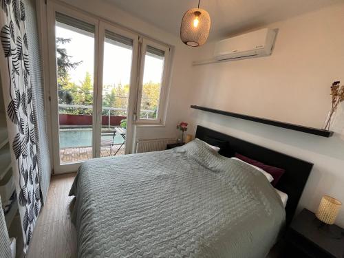 a bedroom with a bed and a large window at Castle View Apartment in Budapest