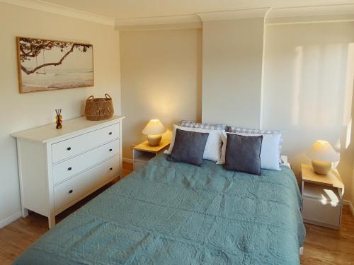 a bedroom with a bed with two lamps and a dresser at Fairways Golf & Beach Retreat Bribie Island in Woorim