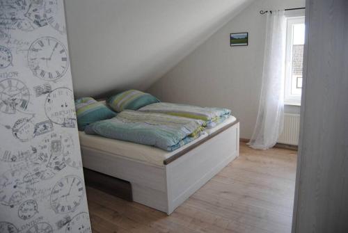 małe łóżko w pokoju z oknem w obiekcie Ferienwohnung Arnold w mieście Vöhl