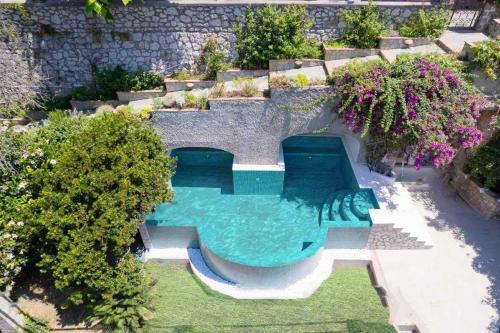 een uitzicht op een zwembad in de achtertuin bij Terrazza Tragara in Capri