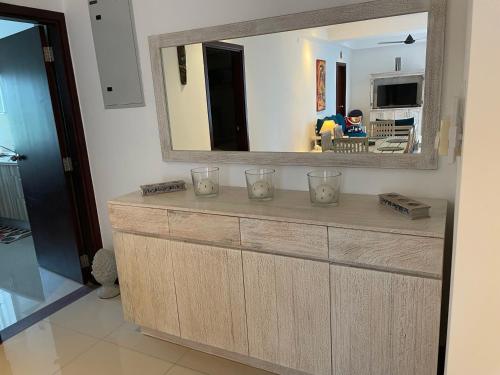 a large mirror above a wooden dresser in a room at Beach Bliss in Trincomalee