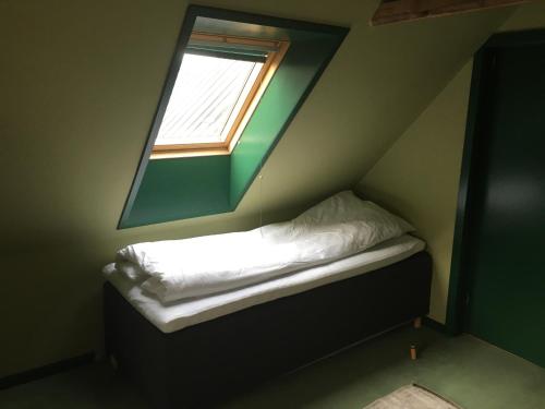 a small bed in a room with a window at Harvey`s Bed & Breakfast in Hjørring