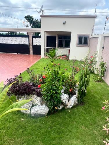 a garden in front of a house with flowers at Boulevard Court in Ejisu