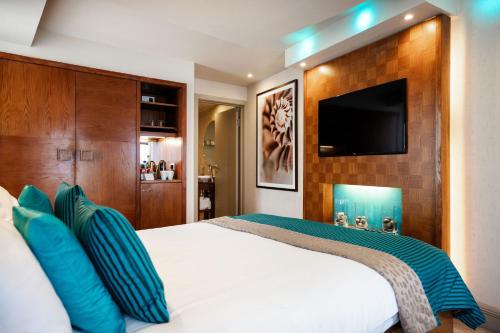 a bedroom with a bed with a flat screen tv at The Royal Yacht in Saint Helier Jersey