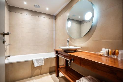 a bathroom with a sink and a mirror at The Royal Yacht in Saint Helier Jersey