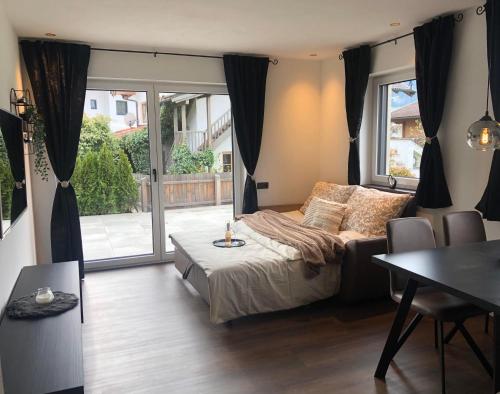 a bedroom with a bed and a table and a window at Appartement Edelschwarz in Westendorf