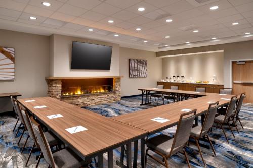 a conference room with tables and chairs and a fireplace at Fairfield by Marriott Inn & Suites Salt Lake City Cottonwood in Holladay