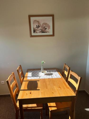 a wooden table with chairs and a vase on it at Apartmány U Šťastných in Cerny Dul