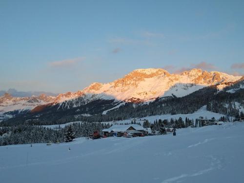 a snow covered mountain with a ski lodge in the foreground at Camera con bagno privato in Tesero