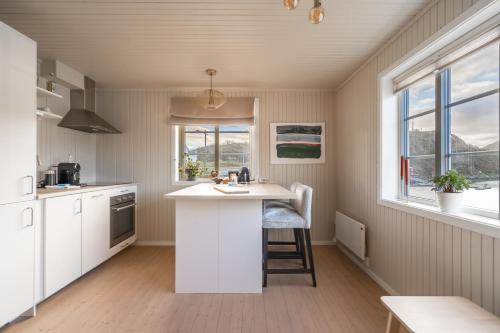 a kitchen with white cabinets and a counter top at Little White House in Reine