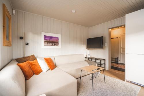 a living room with a white couch and a tv at White House - Panoramic View in Reine