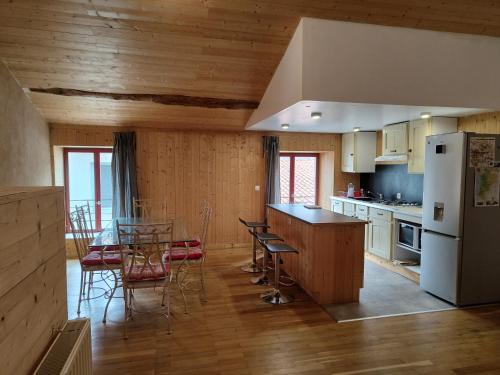 La cuisine est équipée d'une table, de chaises et d'un réfrigérateur. dans l'établissement Le Chalet, à Parthenay