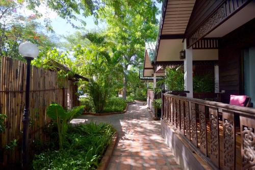 a walkway in front of a house with a fence at Thai Thai Sukhothai Resort in Sukhothai