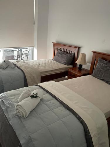 a bedroom with two beds with towels on them at Ocean view 2 Bedroom apartment in Sydney