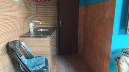 ein Badezimmer mit einem Waschbecken und einer Holzwand in der Unterkunft casa na vila historica in Angra dos Reis