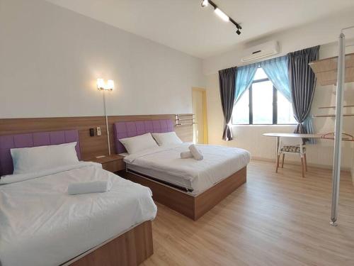 ein Hotelzimmer mit 2 Betten und einem Fenster in der Unterkunft Jentayu Residency Homestay Standard 2 rooms, 6-7guests 3 rooms in Johor Bahru