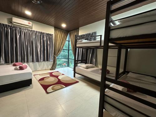 a bedroom with two bunk beds and a window at Santai De Lui Resorts in Kampong Mesjid