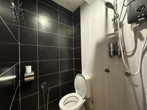 a bathroom with a toilet and a shower at Santai De Lui Resorts in Kampong Mesjid