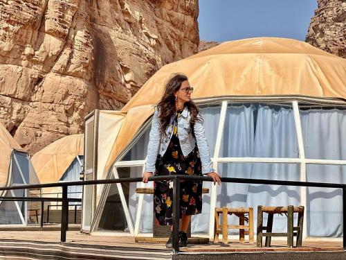 a woman standing in front of a tent at desert princess luxury camp in Wadi Rum