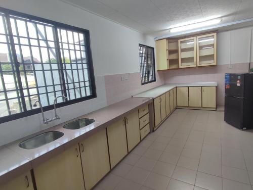 a large kitchen with two sinks and a refrigerator at Ipoh Tambun Sunway 5 Rooms Spacious Homestay in Tambun