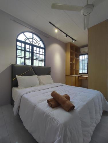 Una gran cama blanca con un animal de peluche. en Ipoh Tambun Sunway 5 Rooms Spacious Homestay en Tambun