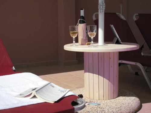 a table with two glasses of wine and a candle at Exanthia Villas in Exanthia