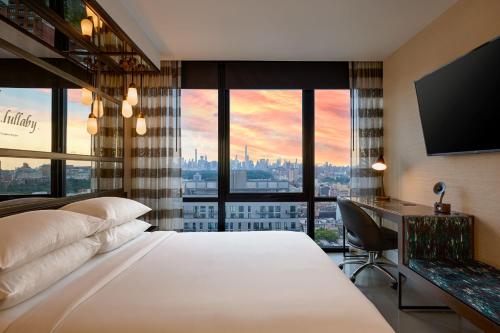 a hotel room with a bed and a desk with a view at Renaissance New York Harlem Hotel in New York